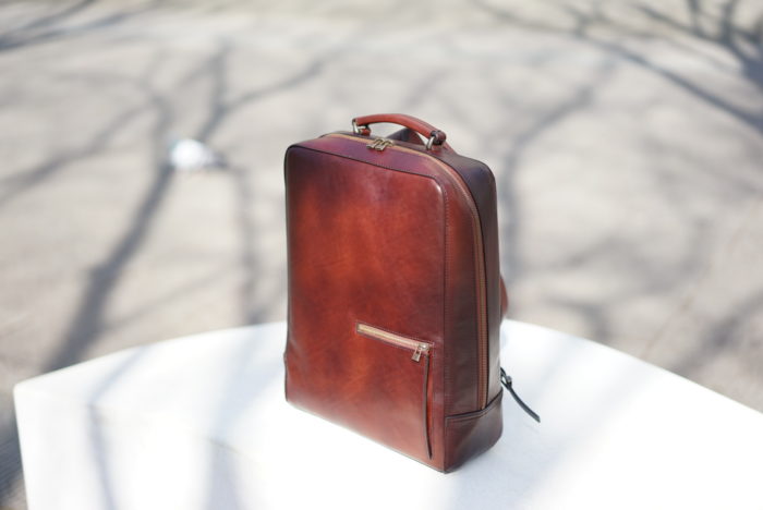 陽の光のもとで輝く antique square backpack